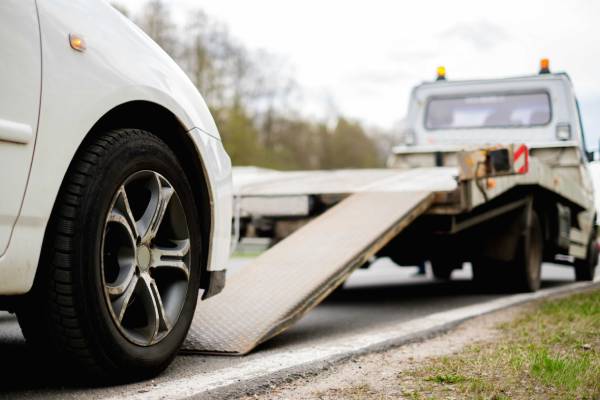 Car being loaded onto tow truck for professional towing services assistance