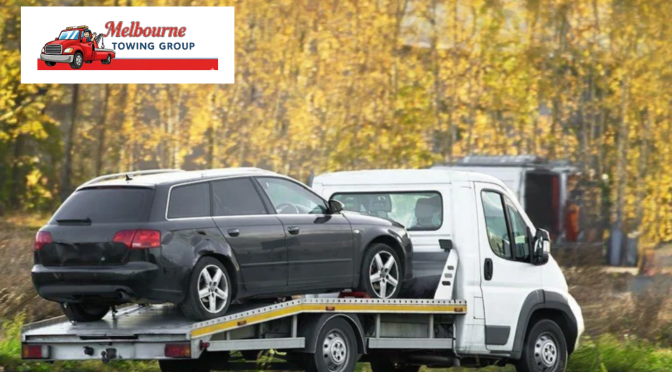 Heavy-duty tow truck transporting a commercial truck after a roadside breakdown.
